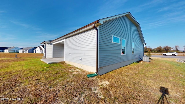 view of side of property with a patio area and a yard