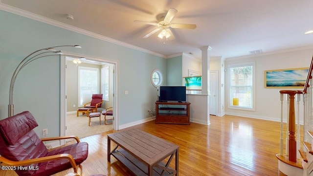 living room with ceiling fan, ornamental molding, and light hardwood / wood-style flooring