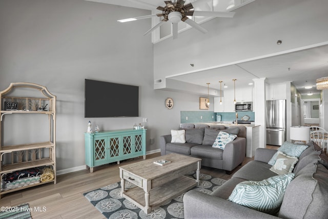 living room featuring ceiling fan and light hardwood / wood-style flooring