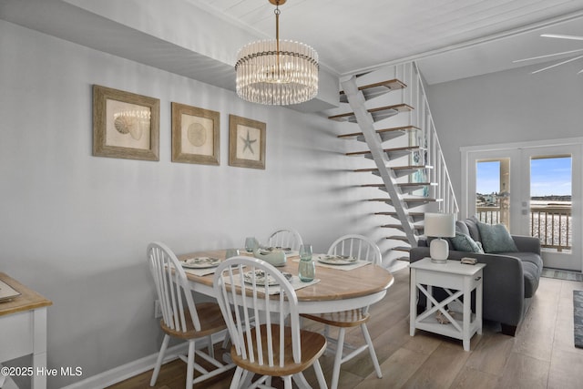 dining room featuring a water view, wood-type flooring, and a notable chandelier