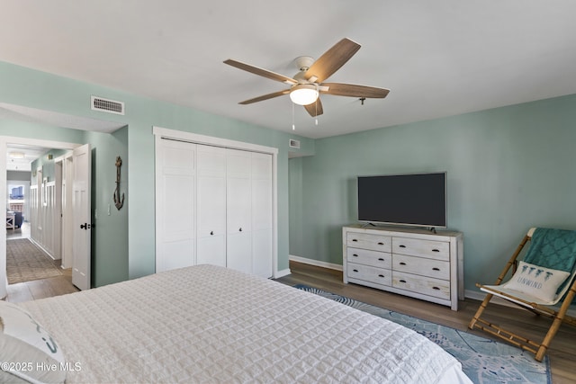 bedroom featuring ceiling fan, a closet, and dark hardwood / wood-style flooring