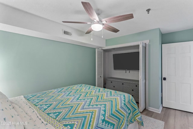 bedroom featuring light wood-type flooring, a closet, and ceiling fan