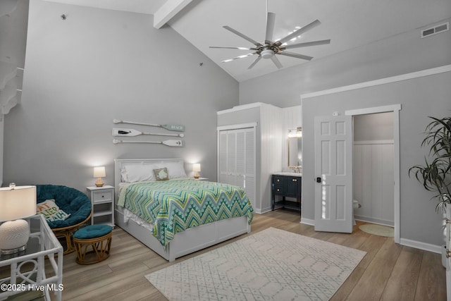 bedroom featuring ceiling fan, light hardwood / wood-style floors, beam ceiling, high vaulted ceiling, and a closet