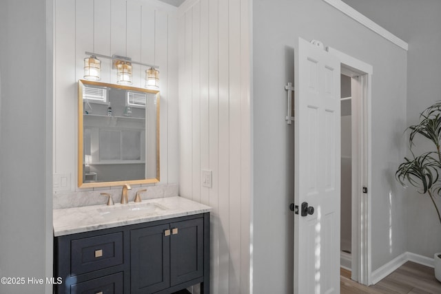 bathroom featuring ornamental molding, hardwood / wood-style flooring, and vanity