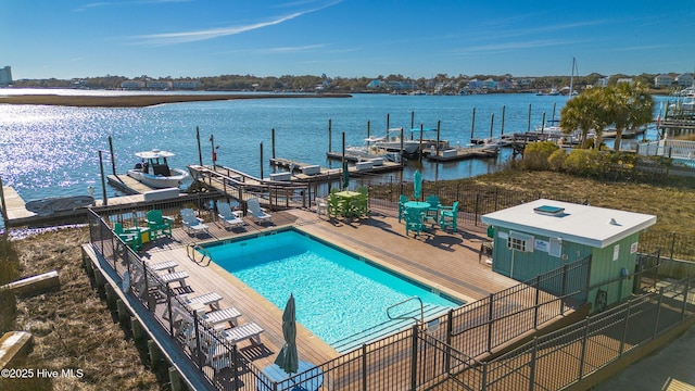 view of swimming pool with a patio area, a dock, and a water view