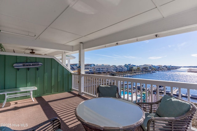 balcony with ceiling fan and a water view