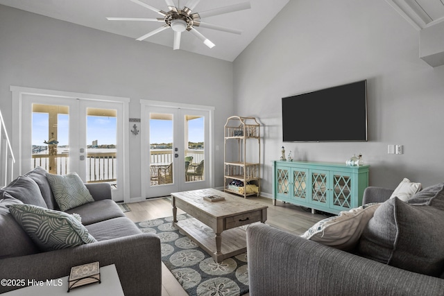 living room featuring ceiling fan, french doors, high vaulted ceiling, and light hardwood / wood-style floors