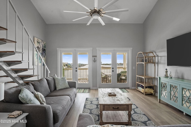 living room featuring ceiling fan, french doors, and light wood-type flooring