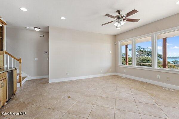 tiled spare room featuring ceiling fan