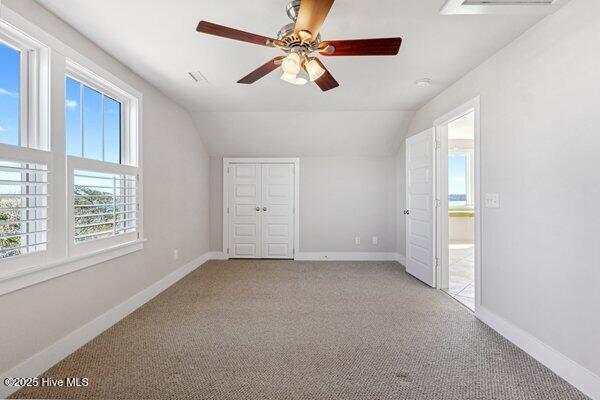 additional living space with ceiling fan, vaulted ceiling, and light carpet