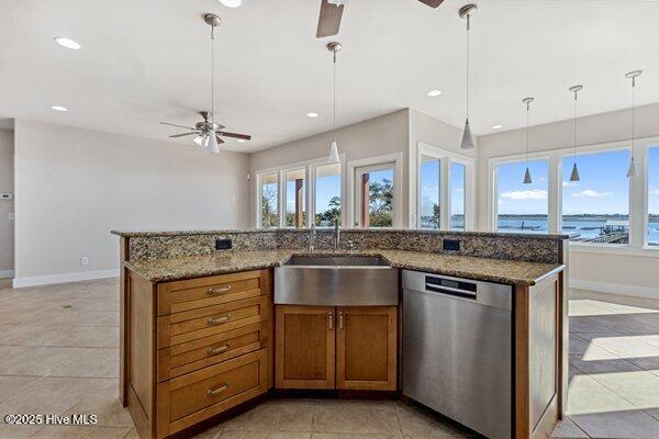 kitchen featuring sink, dishwasher, a spacious island, a water view, and decorative light fixtures