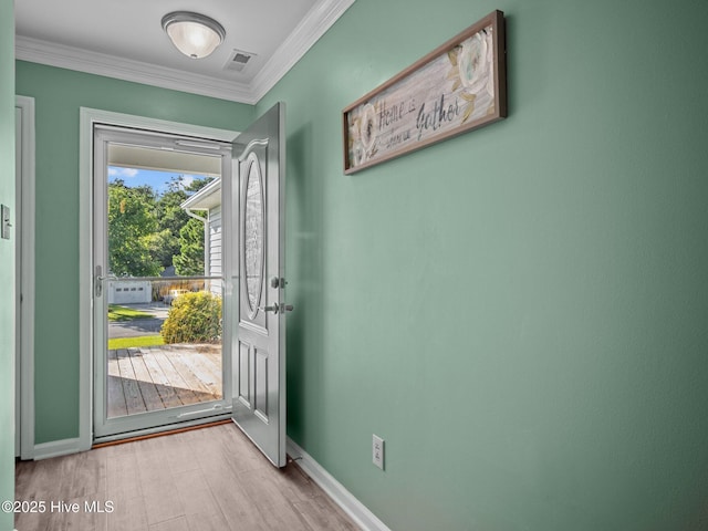 entryway featuring ornamental molding and light hardwood / wood-style floors