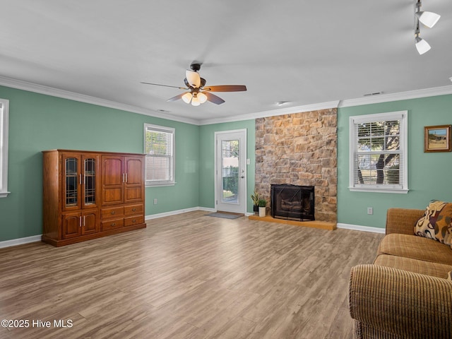 living room with crown molding, a fireplace, and light wood-type flooring