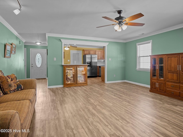 living room featuring crown molding, rail lighting, ceiling fan, and light hardwood / wood-style flooring