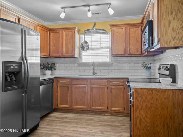 kitchen featuring ornamental molding, appliances with stainless steel finishes, sink, and decorative backsplash