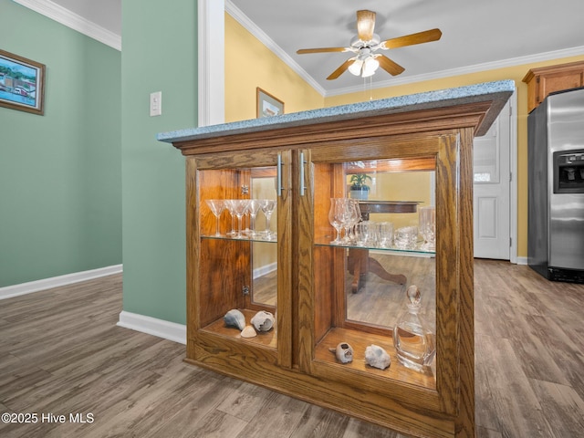 room details featuring hardwood / wood-style flooring, ornamental molding, ceiling fan, and stainless steel fridge with ice dispenser