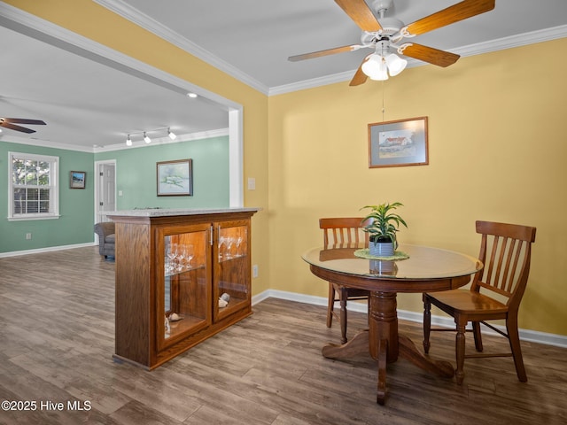 dining room with hardwood / wood-style flooring, ornamental molding, and ceiling fan