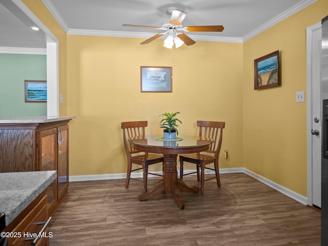 dining area with crown molding, ceiling fan, and dark wood-type flooring