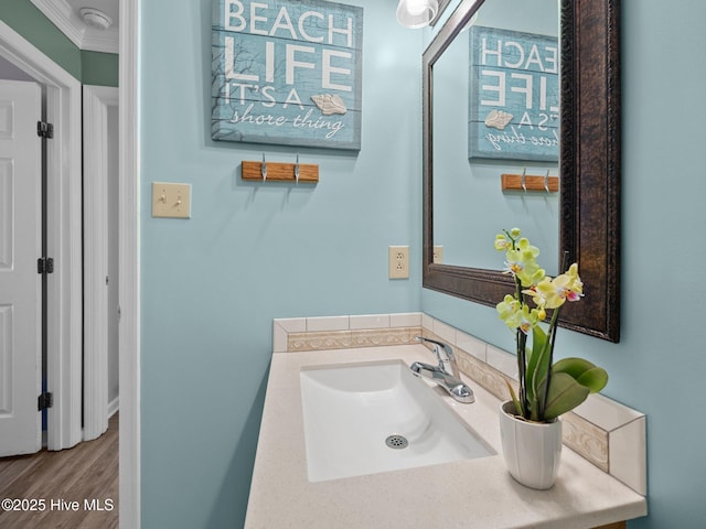 bathroom with vanity, wood-type flooring, and ornamental molding