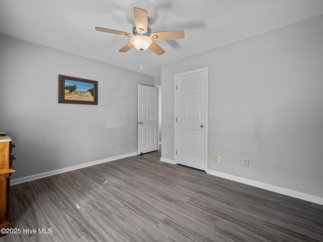 unfurnished bedroom with ceiling fan and dark hardwood / wood-style floors