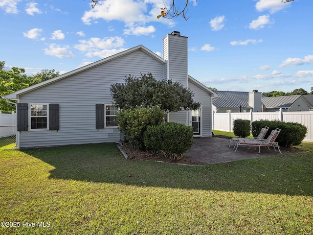 rear view of property featuring a patio and a lawn