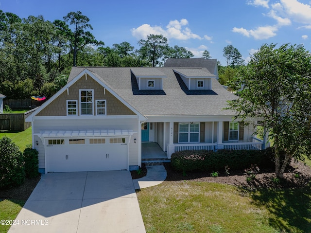 view of front of property with a garage, a front yard, and covered porch