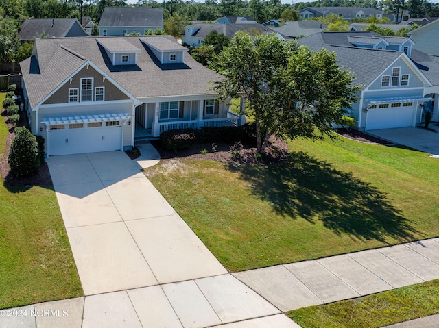 view of front of home with a porch, a garage, and a front yard