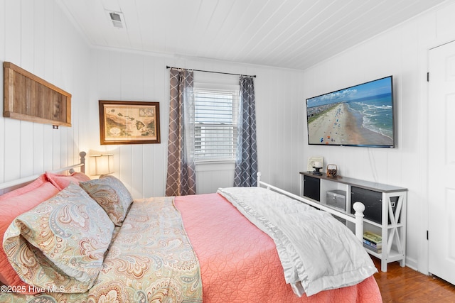 bedroom featuring hardwood / wood-style floors, ornamental molding, wood ceiling, and wooden walls