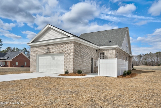 view of front facade with concrete driveway, brick siding, and an attached garage