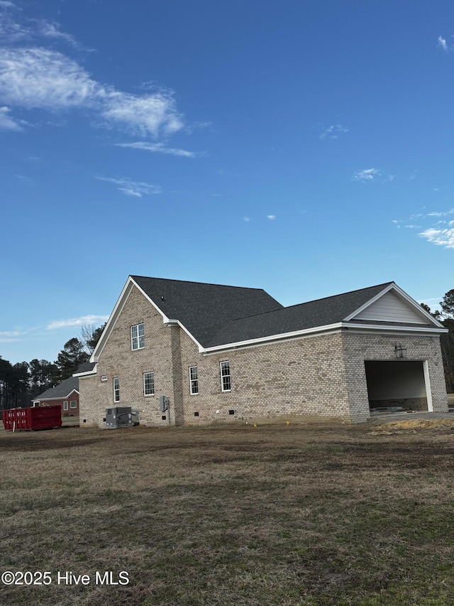 view of side of home featuring a garage and a lawn