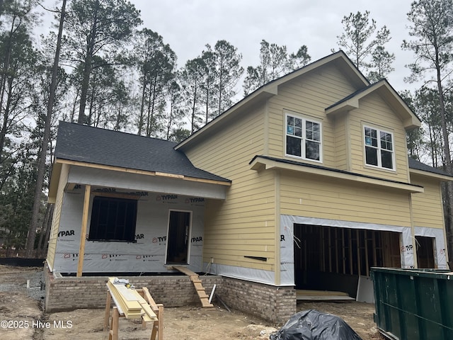 view of front of property with a garage and roof with shingles