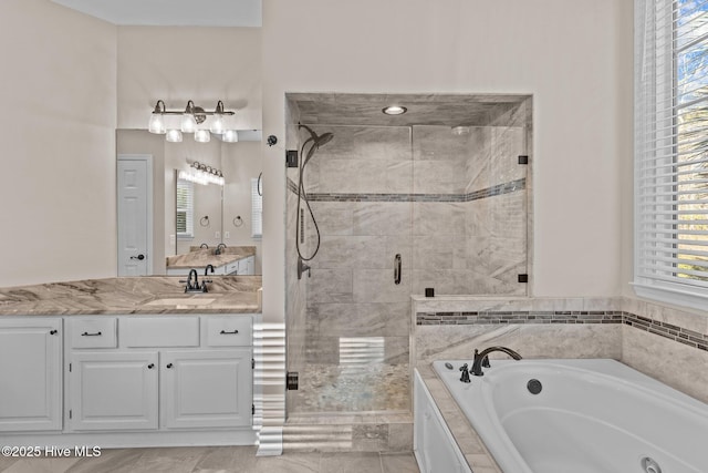 bathroom featuring vanity, a healthy amount of sunlight, and separate shower and tub