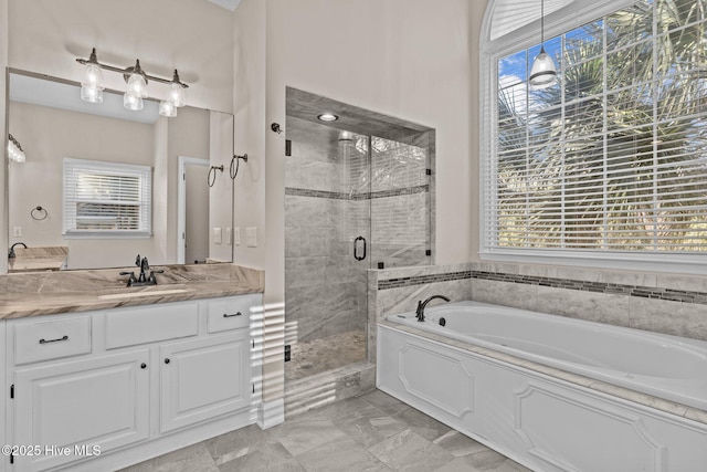 bathroom with plenty of natural light, plus walk in shower, and vanity