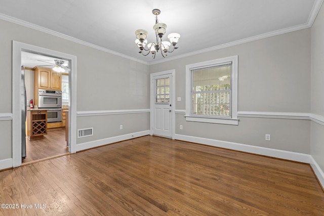 unfurnished dining area featuring an inviting chandelier, hardwood / wood-style floors, and ornamental molding