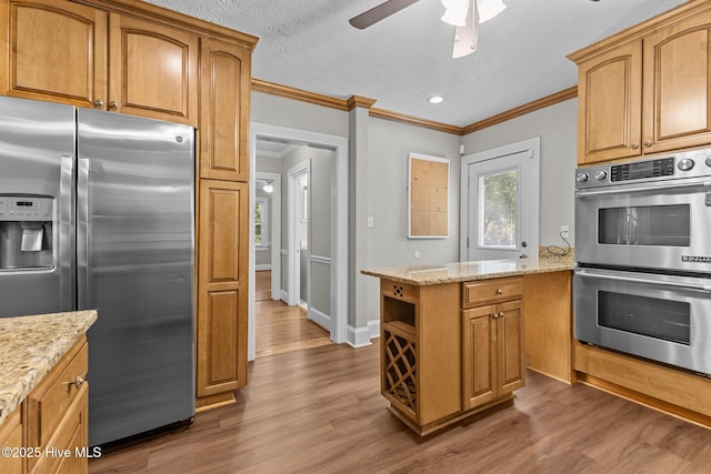 kitchen with light stone counters, crown molding, dark hardwood / wood-style floors, and appliances with stainless steel finishes