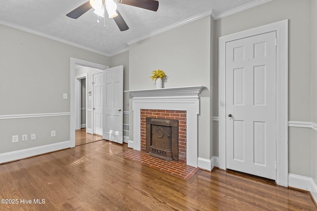 unfurnished living room with a brick fireplace, wood-type flooring, ornamental molding, and a textured ceiling