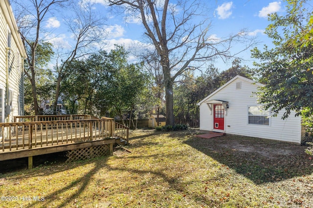 view of yard with a wooden deck and an outbuilding