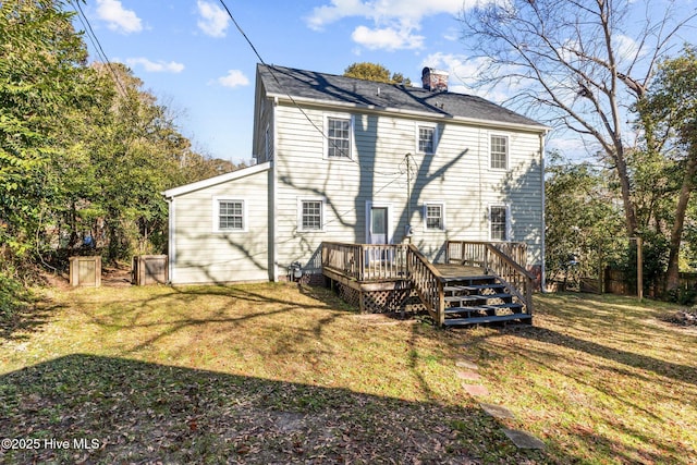 back of property featuring a deck and a lawn