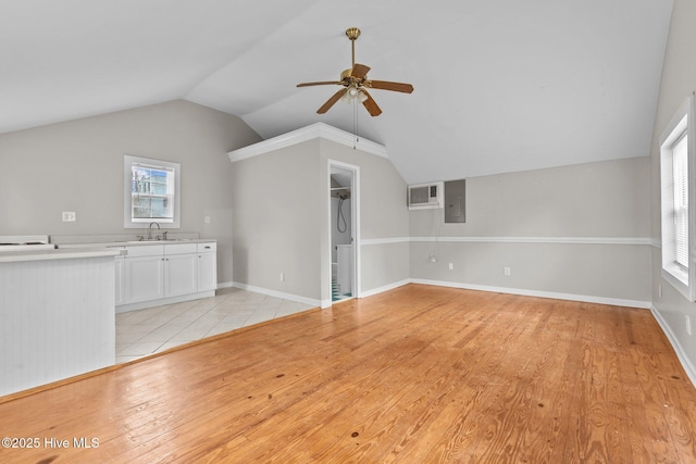 unfurnished living room with sink, vaulted ceiling, ceiling fan, and light wood-type flooring