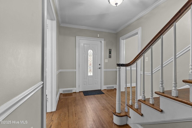 foyer entrance featuring wood-type flooring and ornamental molding