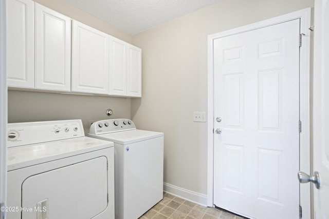 washroom with cabinets, a textured ceiling, and washer and clothes dryer