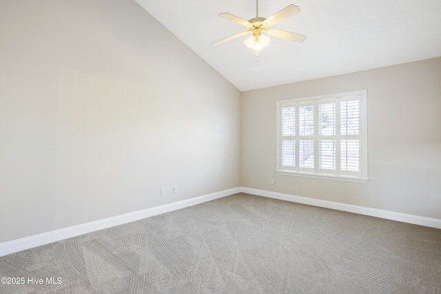 carpeted spare room with ceiling fan and vaulted ceiling