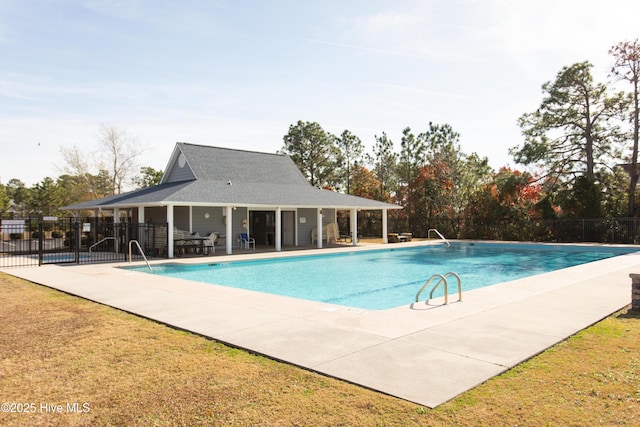 pool with a yard, a patio, and fence