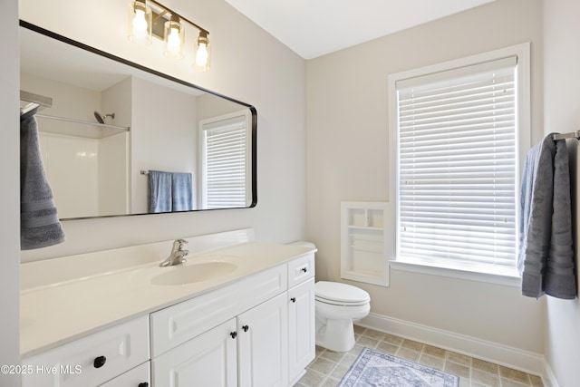 bathroom featuring toilet, walk in shower, and vanity