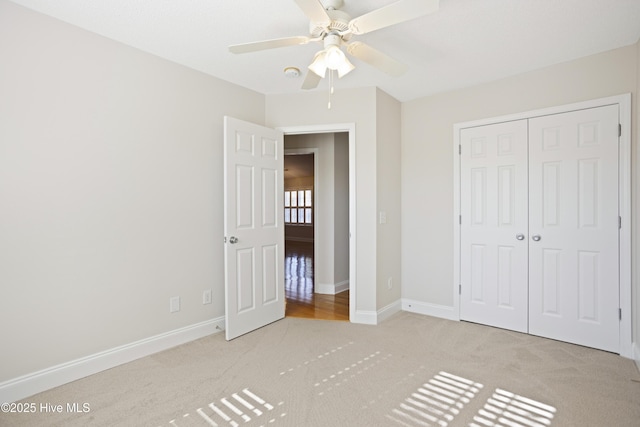 unfurnished bedroom with a closet, ceiling fan, and light carpet