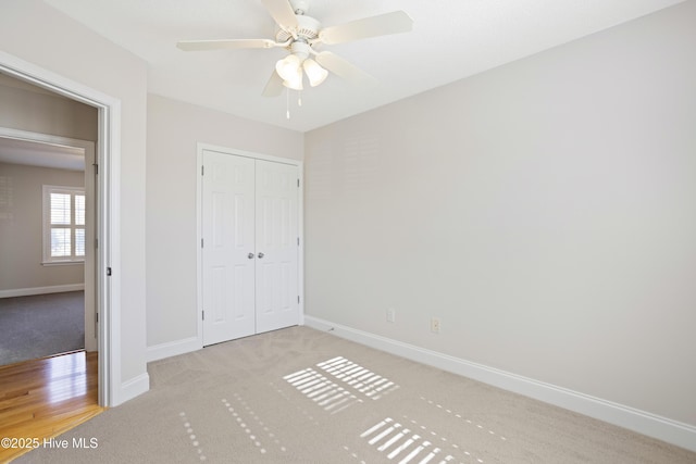 unfurnished bedroom with ceiling fan, a closet, and light carpet