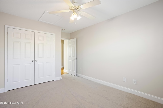 unfurnished bedroom with ceiling fan, light colored carpet, and a closet