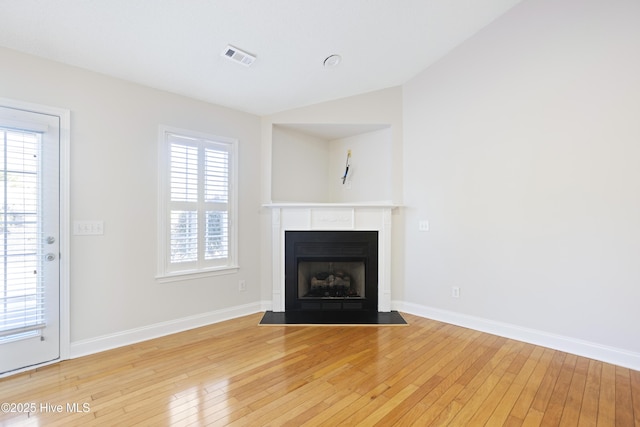 unfurnished living room featuring wood-type flooring and a healthy amount of sunlight