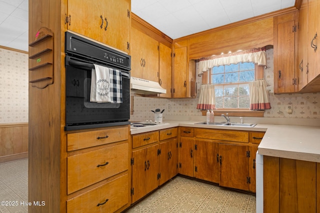 kitchen with sink, white stovetop, wood walls, and oven