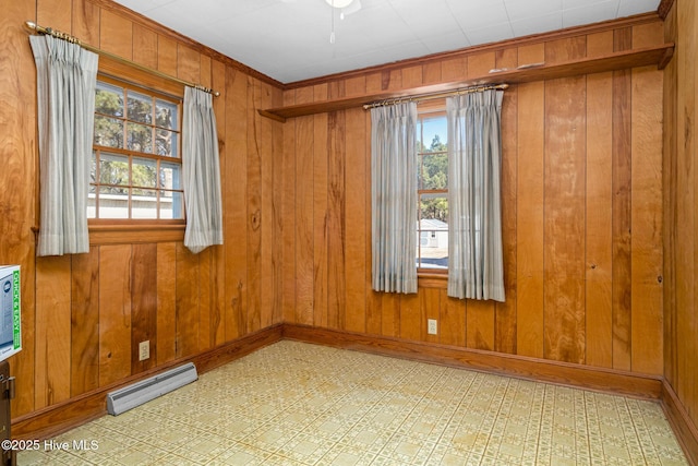 unfurnished room featuring ceiling fan, crown molding, and wood walls